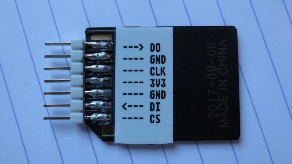 a micro-sd adapter with 7 0.1"-pitch header pins  soldered onto its contacts