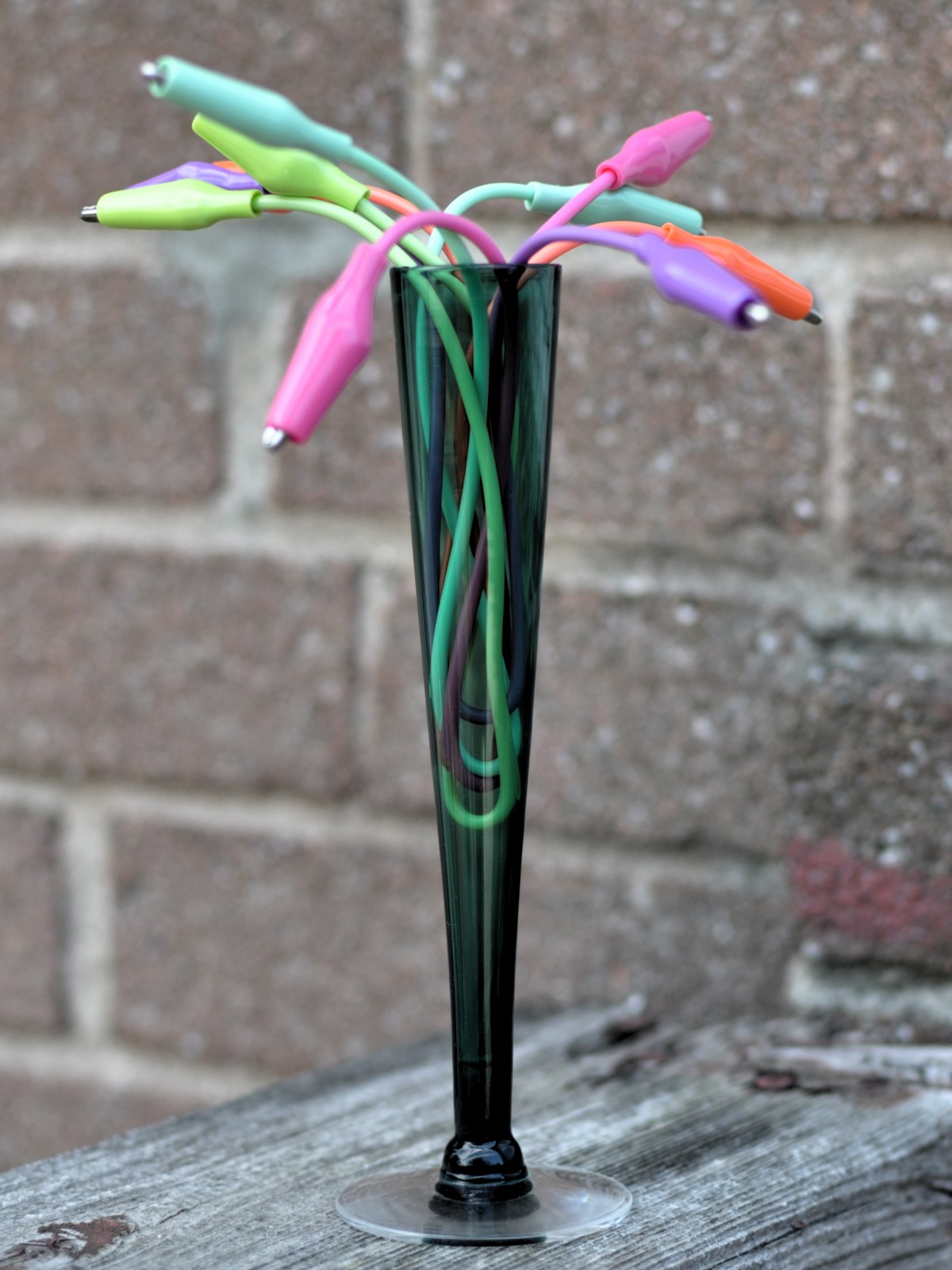 multi-colour alligator clips arranged in a green bud vase as if they were flowering buds